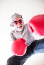 A senior man with sunglasses and boxing gloves having fun at home. Royalty Free Stock Photo