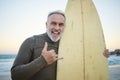 Senior man, with surfboard and at beach smile, happy and at sunset with swimwear on a holiday and vacation. Portrait Royalty Free Stock Photo