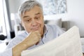 Senior man with surprised look reading newspaper Royalty Free Stock Photo