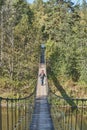Senior man on suspension bridge in nature park. Back view Royalty Free Stock Photo