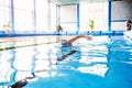 Senior man swimming in an indoor swimming pool. Royalty Free Stock Photo