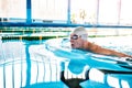 Senior man swimming in an indoor swimming pool. Royalty Free Stock Photo