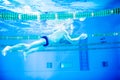 Senior man swimming in an indoor swimming pool. Royalty Free Stock Photo