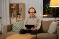 Senior man with tablet pc and headphones at home Royalty Free Stock Photo