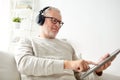 Senior man with tablet pc and headphones at home Royalty Free Stock Photo