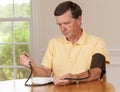 Senior man taking blood pressure at home Royalty Free Stock Photo