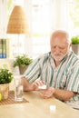 Senior man taking medication at home Royalty Free Stock Photo
