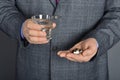 A senior man taking medicine with a glass of water.