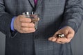 A senior man taking medicine with a glass of water.