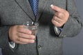 A senior man taking medicine with a glass of water.