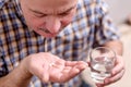 Senior man taking medicine two pills at home Royalty Free Stock Photo