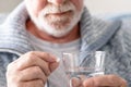 Senior man taking a pill with a glass of water - health care medicine and people concept Royalty Free Stock Photo