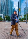 A senior man talking on a cell phone outdoors in the down town Toronto. Elderly man smiling while on the phone