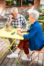 Senior man talking on cellphone during meeting with lady Royalty Free Stock Photo