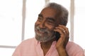 Senior man talking on mobile phone at home Royalty Free Stock Photo