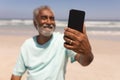 Senior man talking selfie with mobile phone on beach Royalty Free Stock Photo