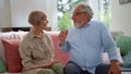 Senior man talking with woman in room. Mature couple having conversation indoors Royalty Free Stock Photo