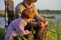 Senior man teach grandson how to put a worm on fishing hook, close-up, side view Royalty Free Stock Photo