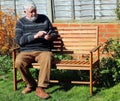 Senior man texting on his cell phone outside. Royalty Free Stock Photo