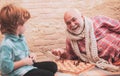 Senior man thinking about his next move in a game of chess. Chess hobbies - granddad with grandson on a playing chess. Royalty Free Stock Photo