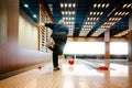 Senior man with throwing bowling ball, captured in modern bowling alley with vibrant lighting Royalty Free Stock Photo