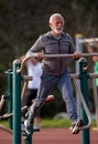 Senior man using sky stepper in public gym Royalty Free Stock Photo