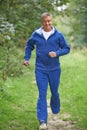 Senior Man In Tracksuit Running Through Countryside