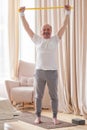 Senior man training at home exercising at home with an elastic band Royalty Free Stock Photo