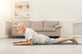 Senior man training yoga in cobra pose indoors Royalty Free Stock Photo