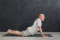 Senior man training yoga in cobra pose indoors Royalty Free Stock Photo