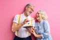 senior man treats a woman with a cake, elderly couple celebrating Royalty Free Stock Photo