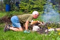 Senior man trying to make a bonfire Royalty Free Stock Photo