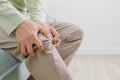 Elderly man suffering from knee pain sitting on sofa at home Royalty Free Stock Photo