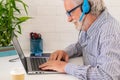 Senior man using laptop computer and mobile phone at home, Businessman working in office.Freelance, studying, technology online Royalty Free Stock Photo