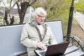 Senior man using laptop computer outdoors Royalty Free Stock Photo