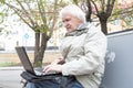 Senior man using laptop computer outdoors Royalty Free Stock Photo