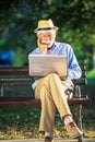 Senior man using laptop computer at rest in the park outdoors Royalty Free Stock Photo