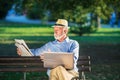 Senior man using laptop computer at rest in the park outdoors Royalty Free Stock Photo