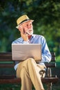 Senior man using laptop computer at rest in the park outdoors Royalty Free Stock Photo