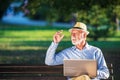 Senior man using laptop computer at rest in the park outdoors Royalty Free Stock Photo