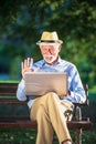 Senior man using laptop computer at rest in the park outdoors Royalty Free Stock Photo