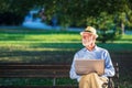 Senior man using laptop computer at rest in the park outdoors Royalty Free Stock Photo