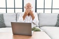 Senior man using laptop at home sitting on the sofa bored yawning tired covering mouth with hand Royalty Free Stock Photo