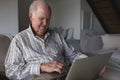 Senior man using laptop in living room Royalty Free Stock Photo