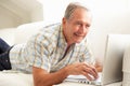 Senior Man Using Laptop Relaxing Sitting On Sofa Royalty Free Stock Photo