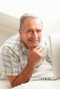 Senior Man Using Laptop Relaxing Sitting On Sofa Royalty Free Stock Photo