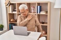 Senior man using laptop suffering for shoulder pain at home Royalty Free Stock Photo