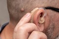 Senior man using modern digital hearing aid Royalty Free Stock Photo