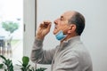 Senior man using an nasal swab for covid 19 detection