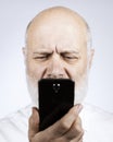Senior man using a phone and having eyesight problems Royalty Free Stock Photo